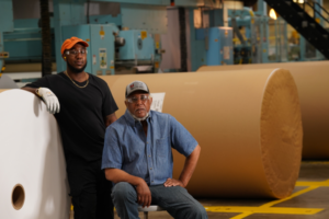 Des membres du syndicat des Métallurgistes unis d'Amérique à côté de rouleaux de papier