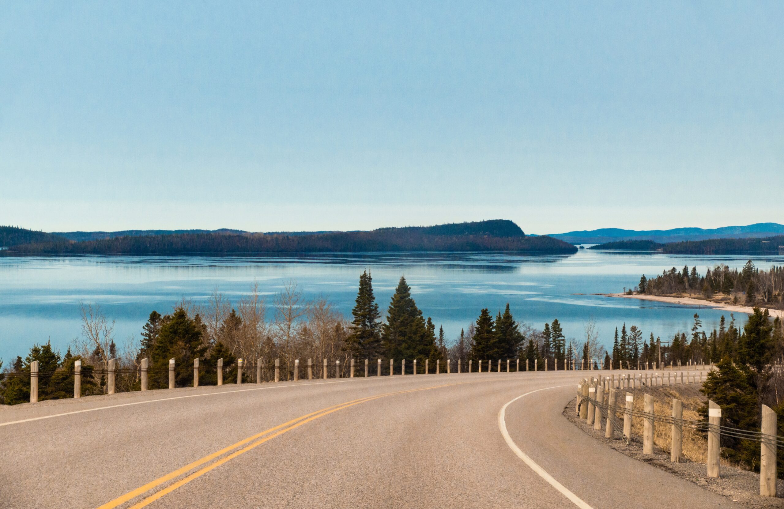 Road with blue skies and water and trees