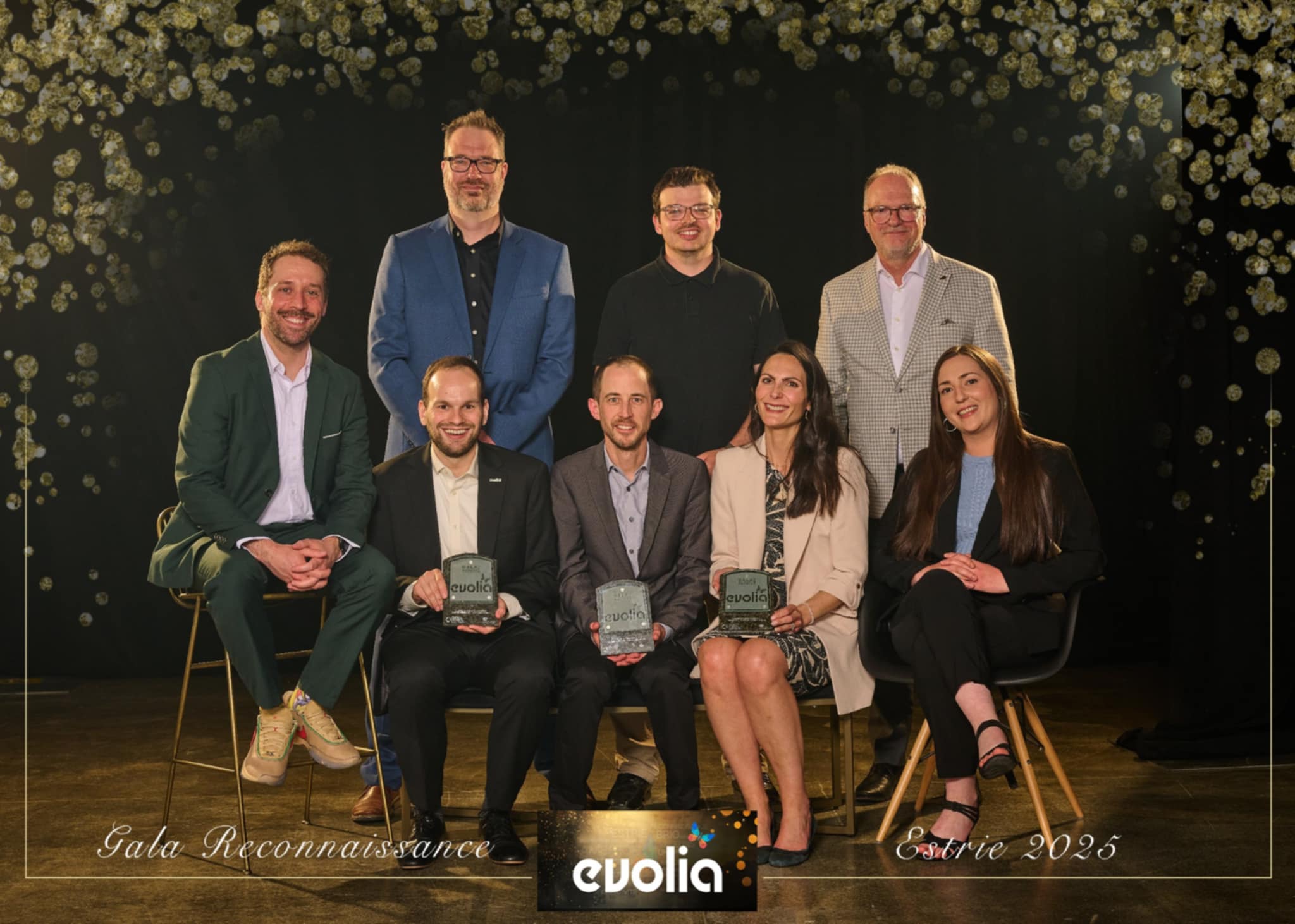 A group of Domtar, La Tribune and Precigrafik representatives celebrate this award-winning local printing partnership. There are eight men and women in the photo. Credit: Evolia