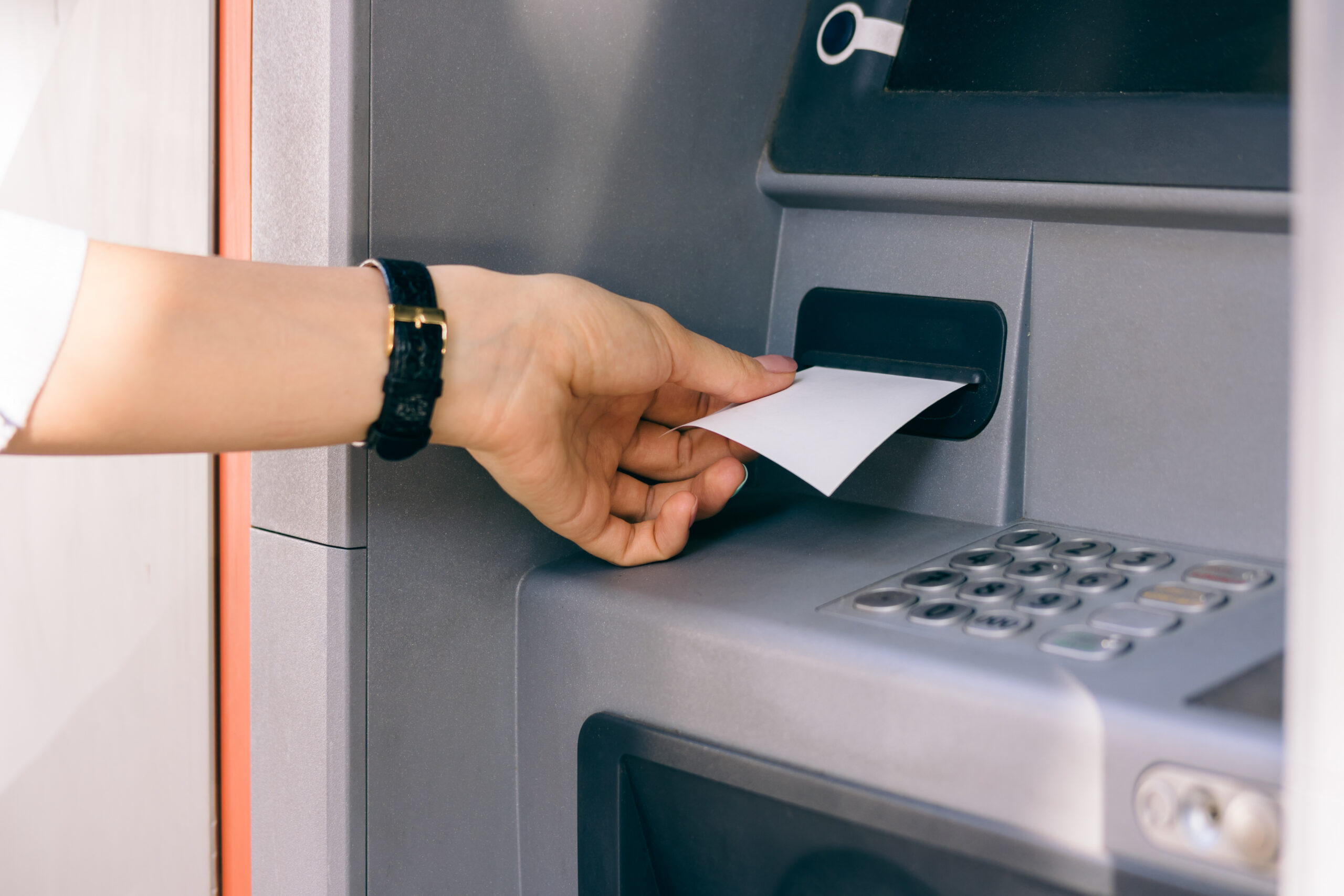 Female Hand Holding A Receipt Obtained From The Atm