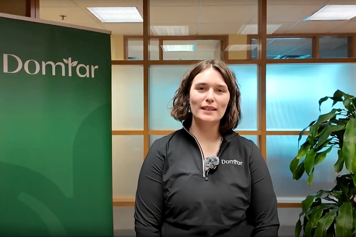 Image: A woman, Samantha Morrissey, talking to a camera in front of a green Domtar banner. As part of our commitment to promote responsible forestry and support rural communities in the U.S., we collaborate with private landowners.