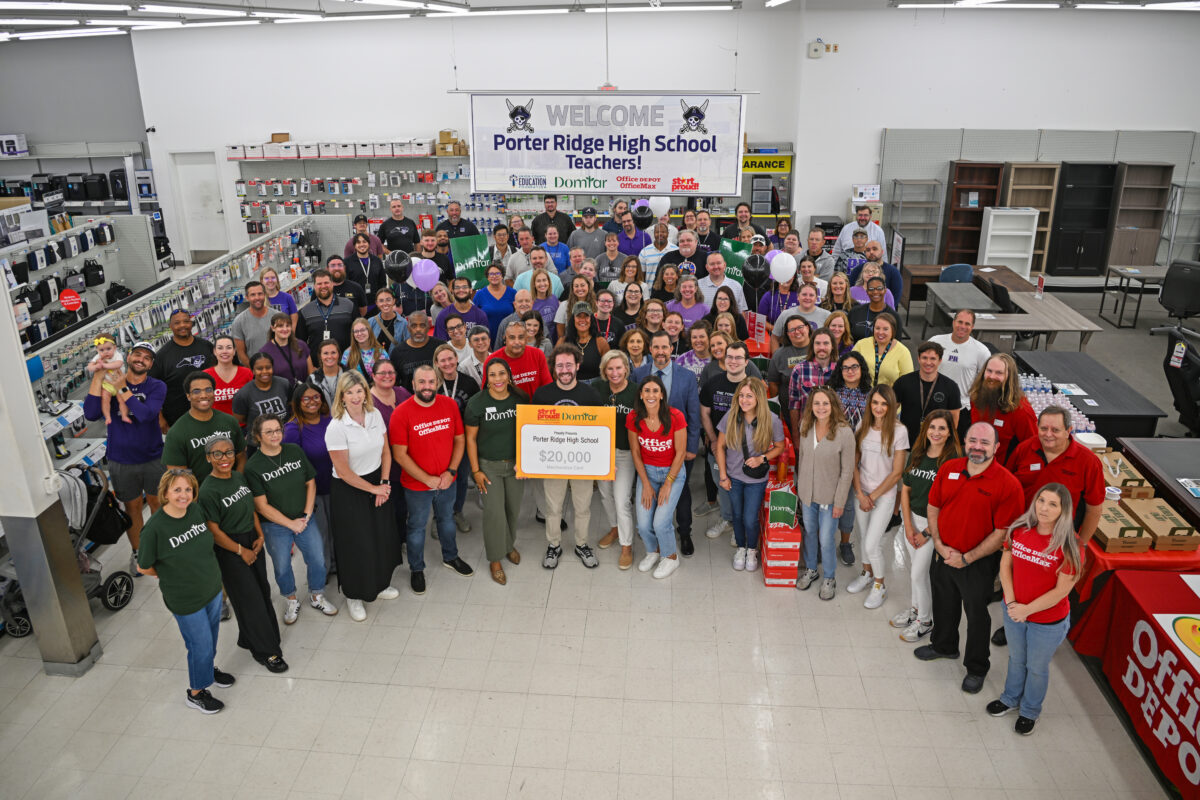 Image description: Large group of men and women in an office supply store, holding a sign recognizing Domtar's contribution to the Start Proud program. Domtar partners with Start Proud!®, Office Depot’s signature back-to-school community investment program